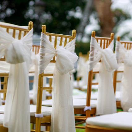 Party & EventGolden wedding chairs with white linens tied to the background of them